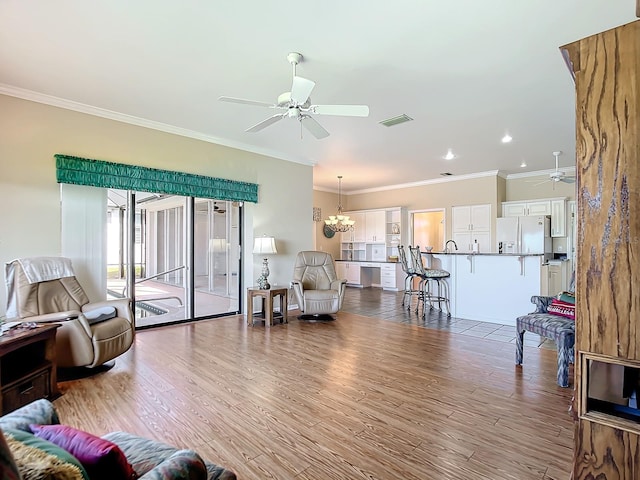 living room featuring crown molding, light hardwood / wood-style floors, and ceiling fan