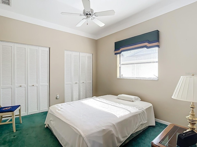 carpeted bedroom featuring ceiling fan and two closets