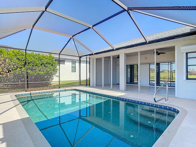 view of pool featuring a patio area, glass enclosure, and ceiling fan