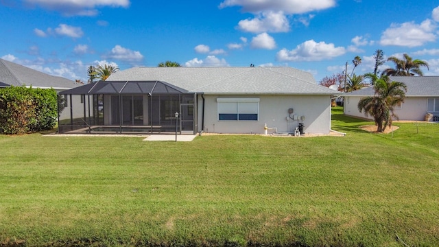 rear view of house with a patio area, glass enclosure, and a lawn