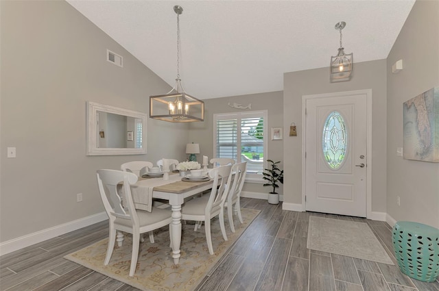 dining room featuring a notable chandelier, dark hardwood / wood-style floors, and vaulted ceiling