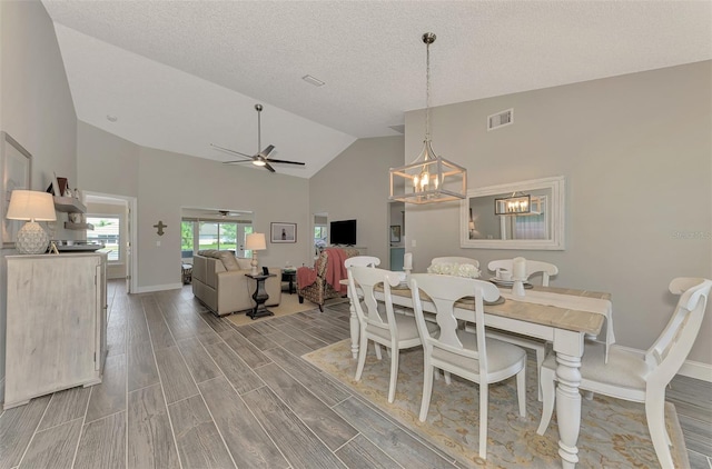 dining area with a textured ceiling, ceiling fan with notable chandelier, high vaulted ceiling, and light hardwood / wood-style floors