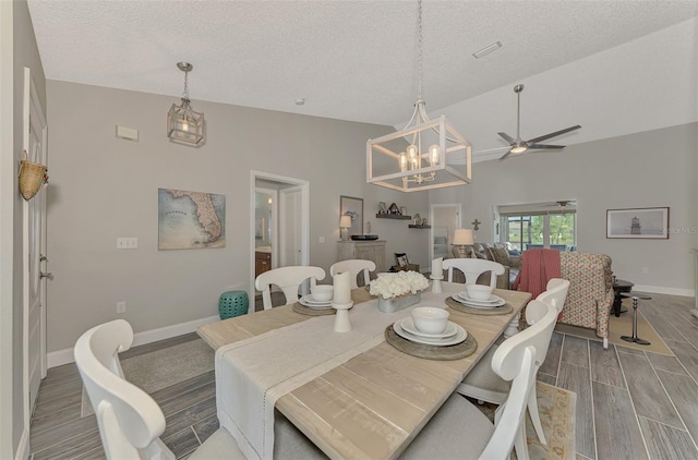 dining room featuring a textured ceiling, high vaulted ceiling, wood-type flooring, and ceiling fan with notable chandelier