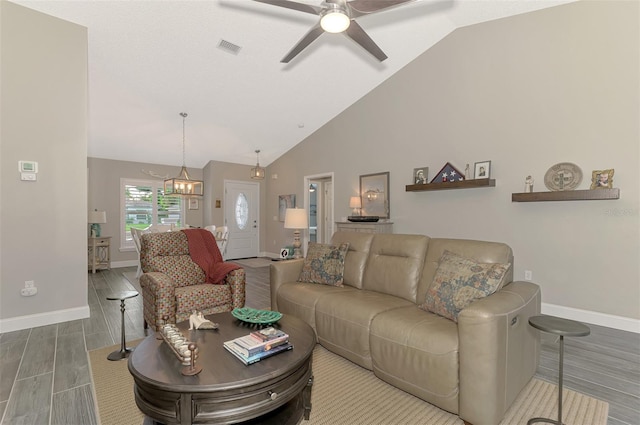 living room with high vaulted ceiling, hardwood / wood-style flooring, and ceiling fan with notable chandelier