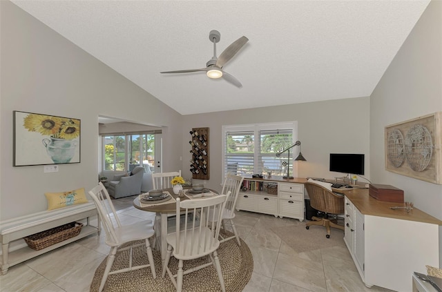 dining area with a textured ceiling, high vaulted ceiling, light tile patterned floors, and ceiling fan