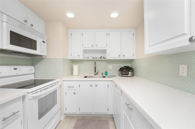 kitchen with white appliances, tasteful backsplash, sink, white cabinets, and light tile patterned floors