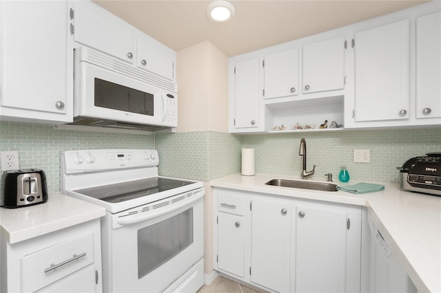 kitchen with decorative backsplash, white cabinets, and white appliances