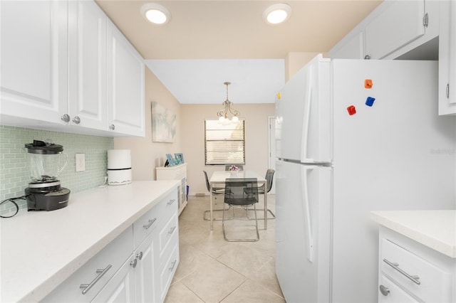 kitchen with white cabinetry, decorative light fixtures, decorative backsplash, light tile patterned floors, and white refrigerator