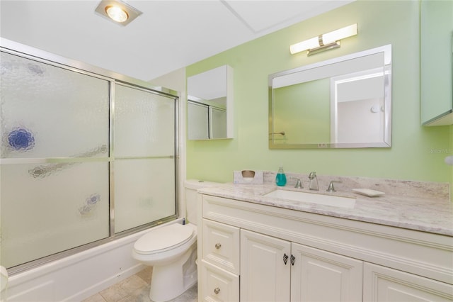 full bathroom featuring vanity, bath / shower combo with glass door, toilet, and tile patterned floors