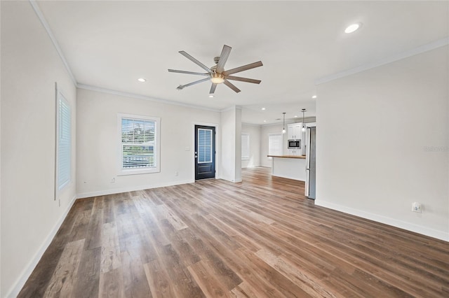 unfurnished living room with ceiling fan, wood-type flooring, and ornamental molding