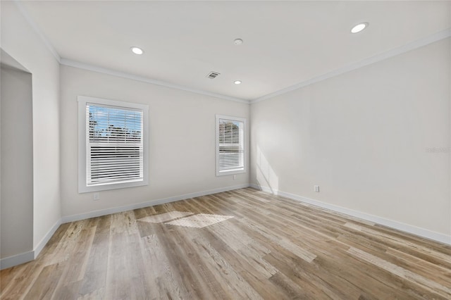 spare room featuring light hardwood / wood-style floors and crown molding