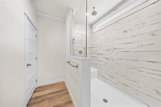 bathroom with tiled shower, ornamental molding, and hardwood / wood-style flooring