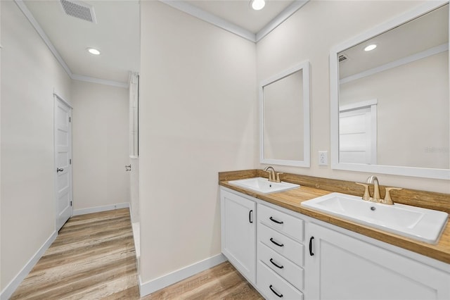 bathroom featuring vanity, ornamental molding, and hardwood / wood-style floors