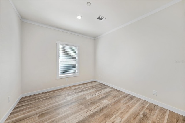 empty room featuring ornamental molding and light hardwood / wood-style flooring