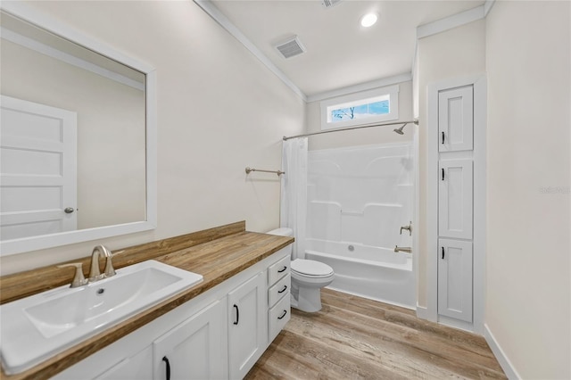 full bathroom featuring wood-type flooring, toilet, ornamental molding, vanity, and shower / tub combo with curtain