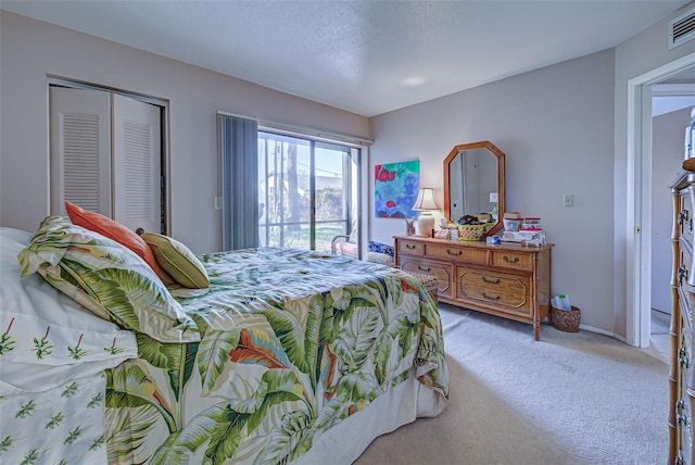 carpeted bedroom with a closet, a textured ceiling, and access to exterior