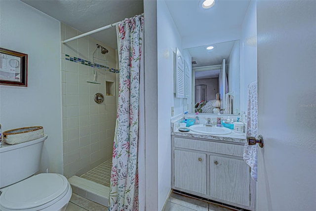 bathroom with toilet, curtained shower, vanity, and tile patterned flooring