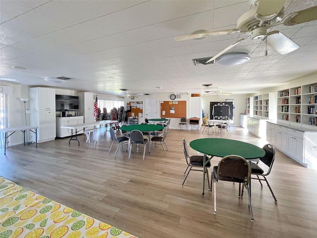 dining space with light wood-type flooring and ceiling fan