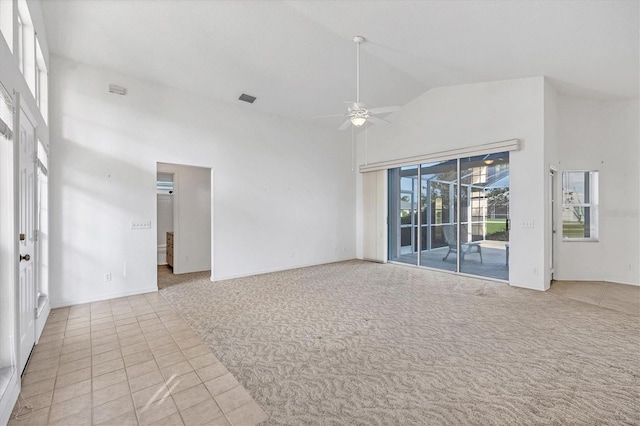 carpeted spare room featuring high vaulted ceiling and ceiling fan