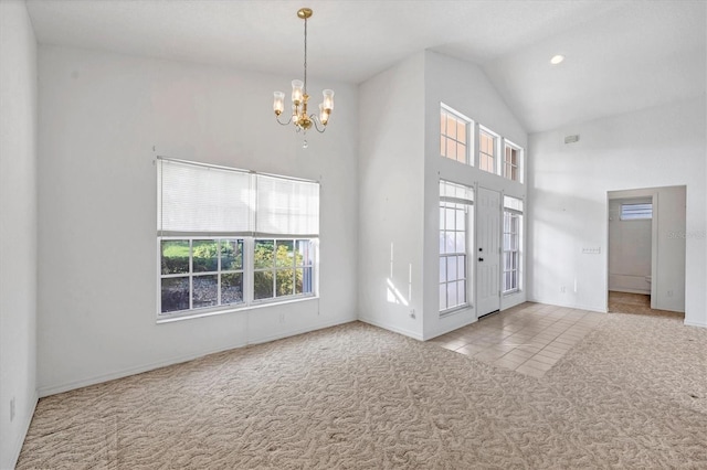 carpeted entrance foyer with high vaulted ceiling and a chandelier