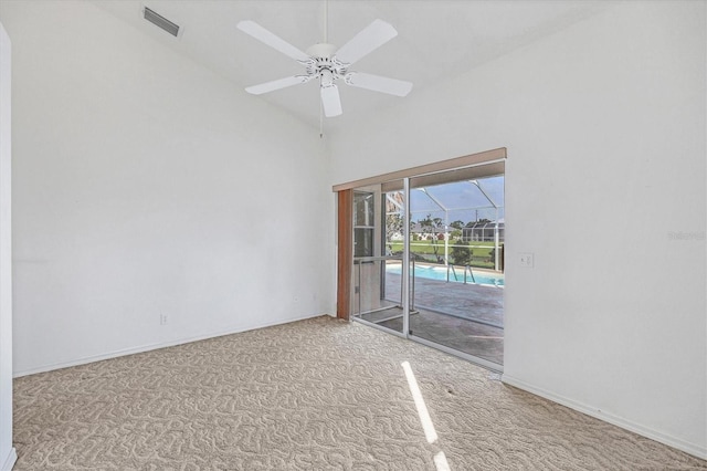 carpeted empty room with high vaulted ceiling and ceiling fan