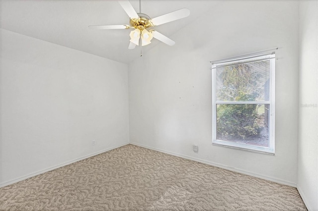 spare room featuring vaulted ceiling, light colored carpet, and ceiling fan