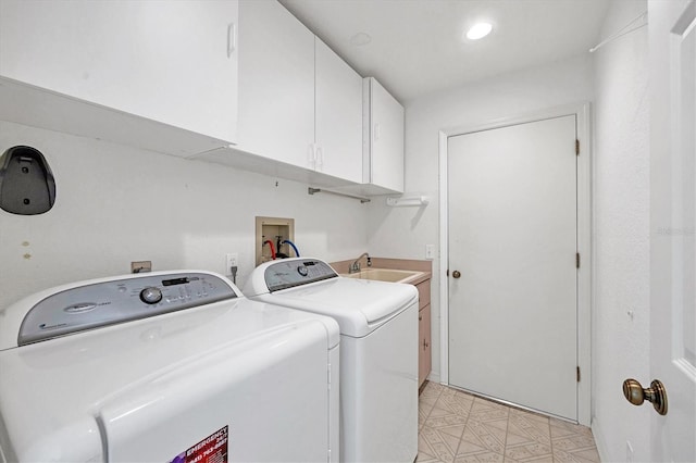 clothes washing area featuring sink, cabinets, and washing machine and clothes dryer