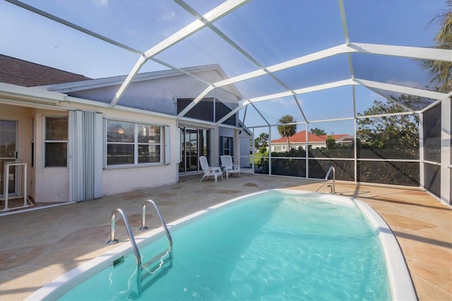 view of pool with a patio area and glass enclosure