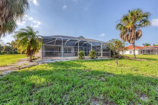 rear view of house featuring a yard, a patio, and a lanai