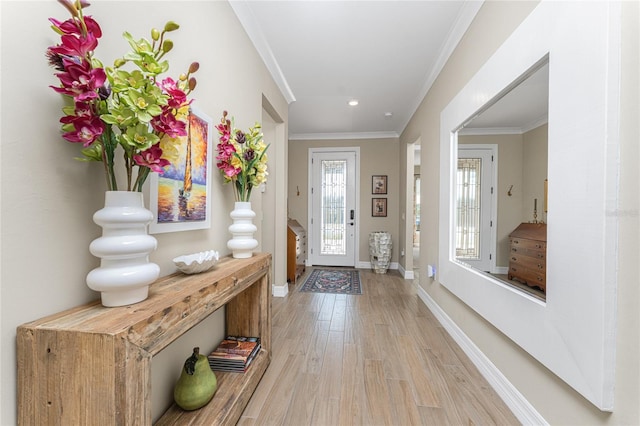 entryway with ornamental molding and light wood-type flooring