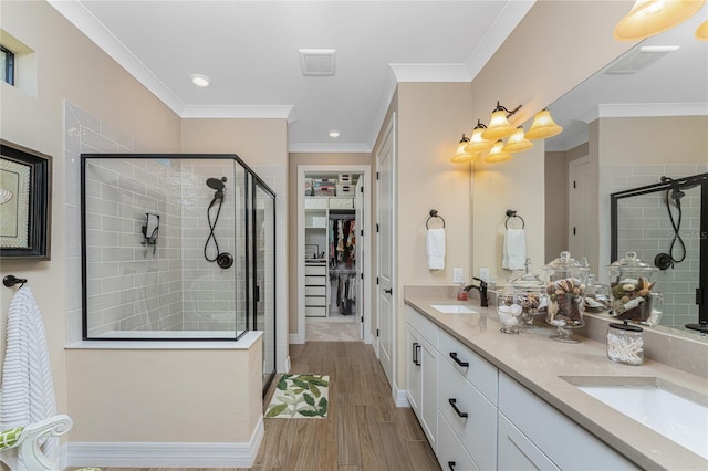 bathroom with vanity, crown molding, a shower with door, and hardwood / wood-style floors