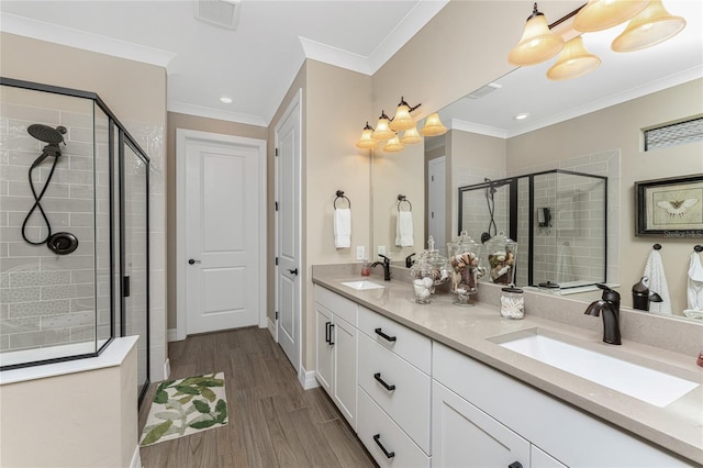 bathroom featuring vanity, crown molding, wood-type flooring, and walk in shower