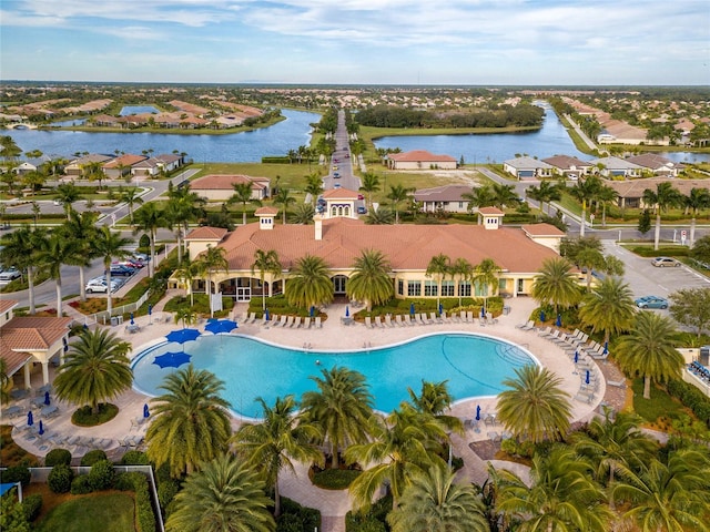 view of pool featuring a water view and a patio