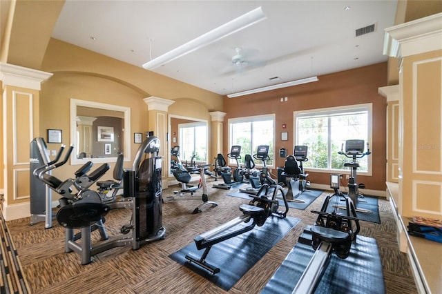 workout area with ornate columns, carpet floors, and ceiling fan