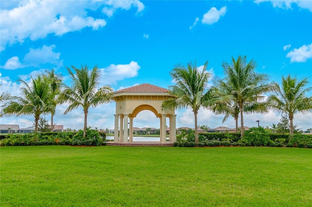 view of home's community with a gazebo, a water view, and a lawn