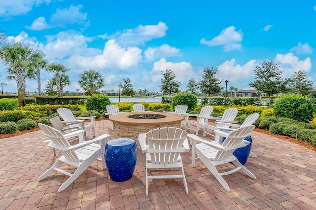 view of patio / terrace with an outdoor fire pit and a water view