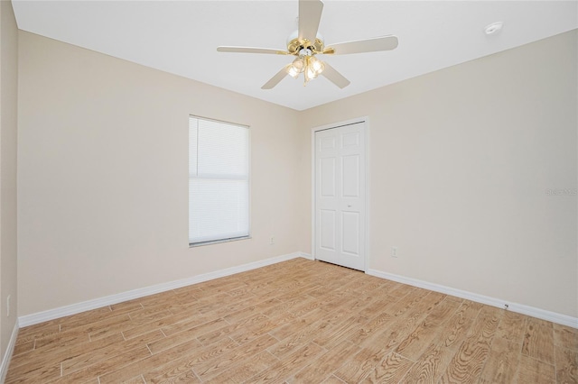 empty room with ceiling fan and light hardwood / wood-style flooring