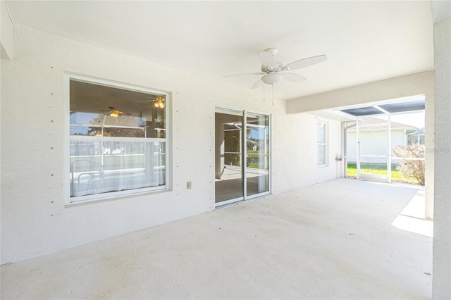 view of patio featuring glass enclosure and ceiling fan