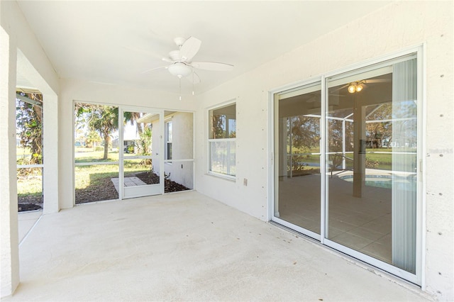 unfurnished sunroom featuring ceiling fan