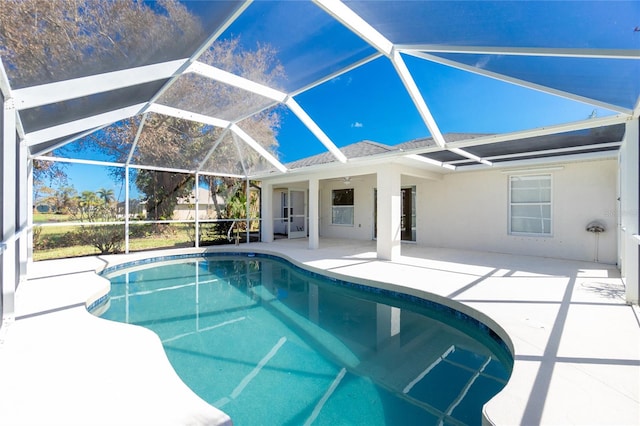 view of swimming pool with a patio area and glass enclosure