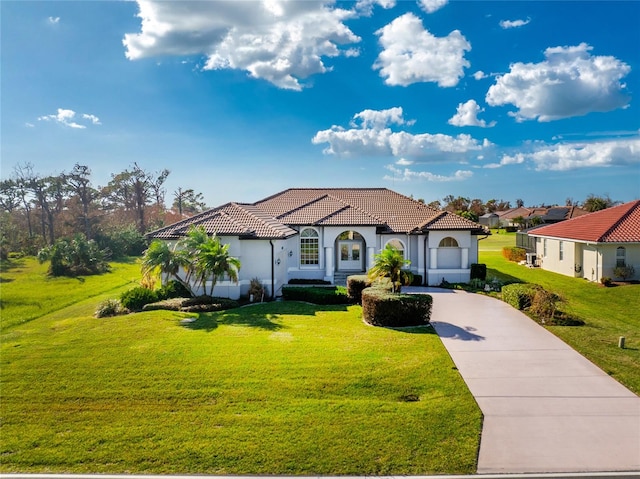 mediterranean / spanish-style house with a garage and a front lawn