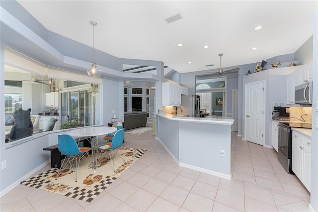 kitchen featuring appliances with stainless steel finishes, white cabinets, backsplash, and pendant lighting