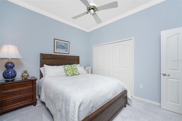 bedroom featuring ornamental molding, light carpet, a closet, and ceiling fan