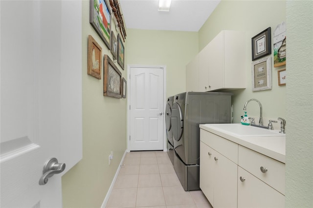 laundry area featuring cabinets, light tile patterned flooring, sink, and washing machine and clothes dryer