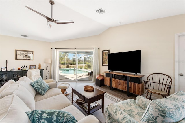 living room featuring hardwood / wood-style floors, vaulted ceiling, and ceiling fan