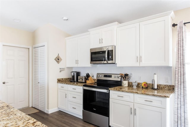 kitchen featuring appliances with stainless steel finishes, light stone counters, white cabinets, and dark hardwood / wood-style flooring