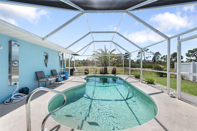 view of pool featuring a lawn, a patio area, and glass enclosure