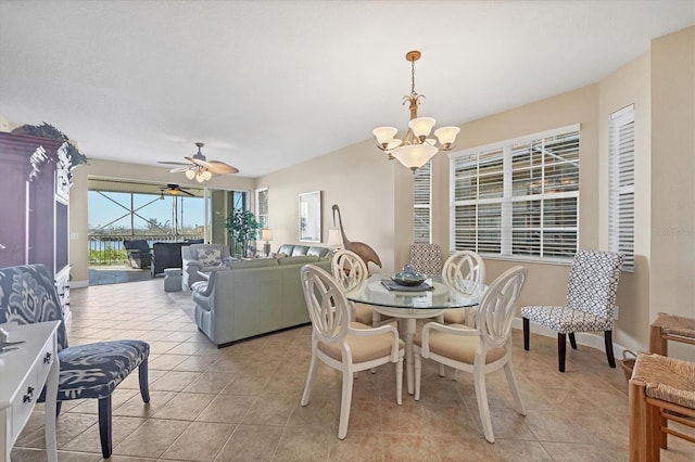 dining area with light tile patterned floors and ceiling fan with notable chandelier