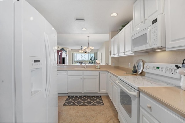 kitchen with sink, white cabinets, decorative light fixtures, and white appliances