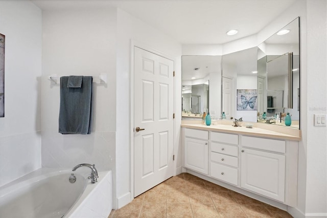 bathroom with tile patterned flooring, vanity, and a relaxing tiled tub